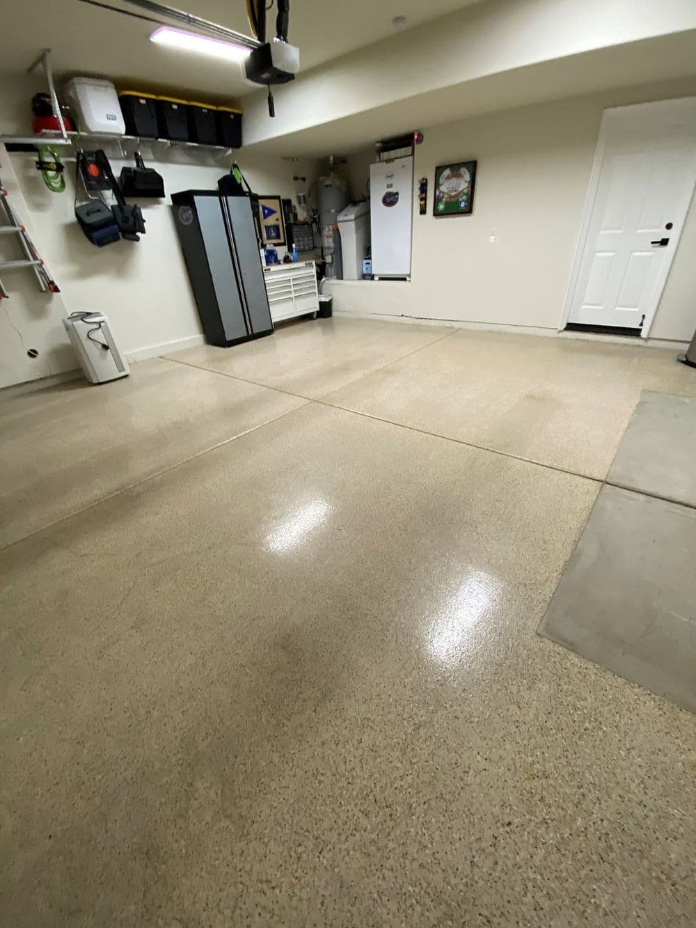 Clean and organized garage with polished floor, storage cabinets, and wall mounts.