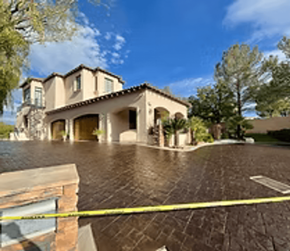 Elegant luxury home with a landscaped driveway and blue sky in the background.